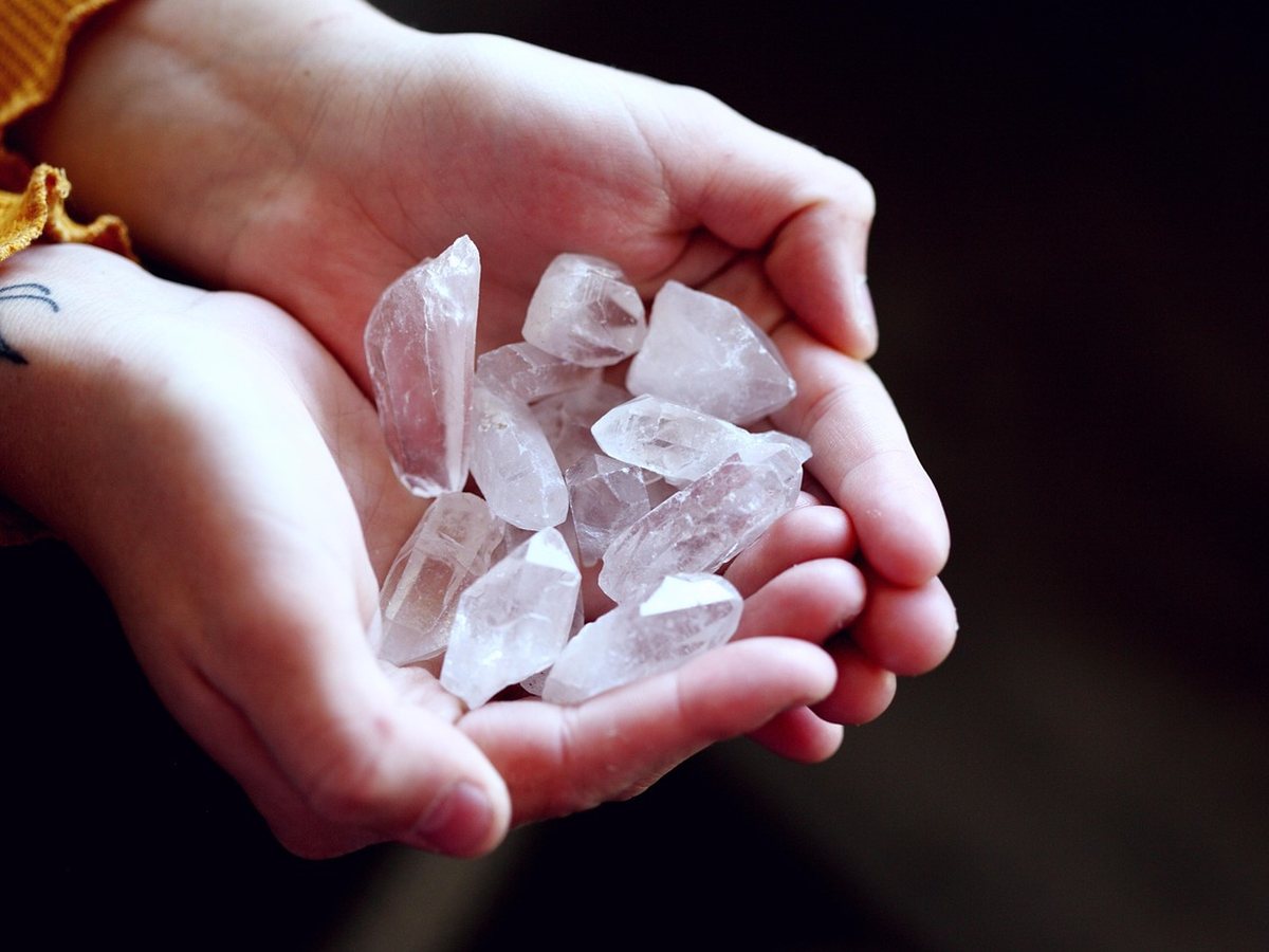 Mains tenant un cristal de quartz pour un soin énergétique